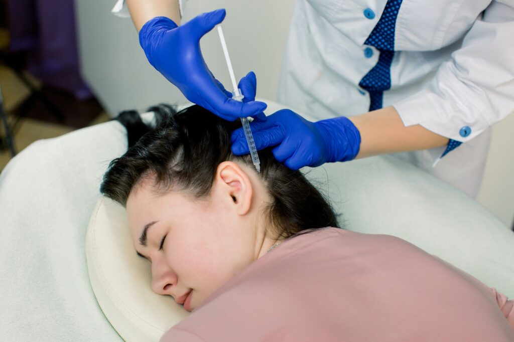 Hair loss problem, mesotherapy. Woman with hair loss problem receiving injection in beauty center